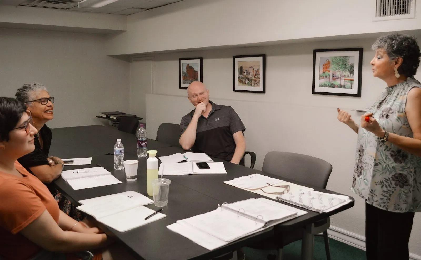 Clase de conversación de Language Plus en El Paso: una instructora charla con un grupo chico de adultos alrededor de una mesa